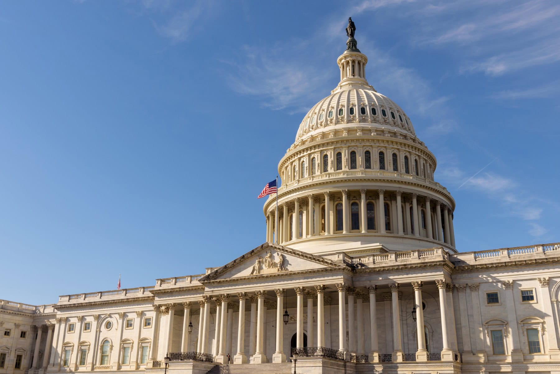 The United States Capitol building with the American flag flying atop its flagpole, Washington DC The United States Capitol building with the American flag flying atop its flagpole, Washington DC
