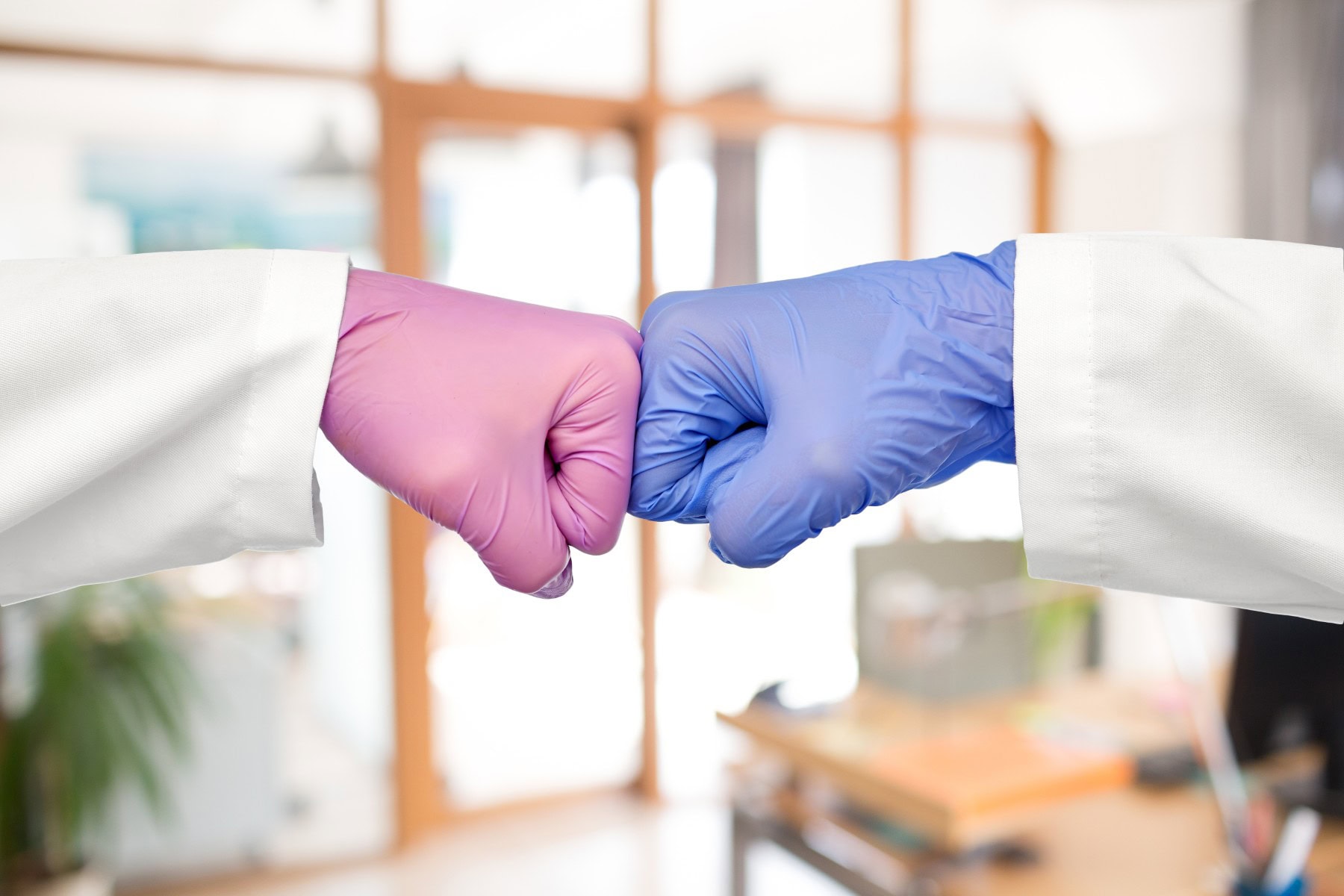 Two medical professionals engaged in a fist bump